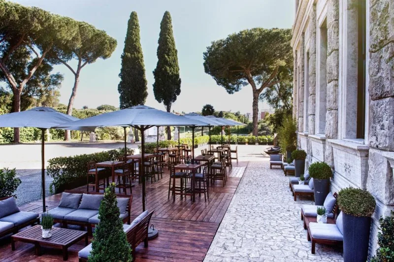 TH Roma Carpegna Palace - la terrazza con divani e ombrelloni tra i pini